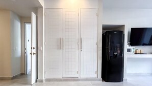 A modern kitchen with white cabinets, a black refrigerator, and a microwave on the countertop. - Ixchel Beach Hotel. Steps away from North Beach (Isla Mujeres)
