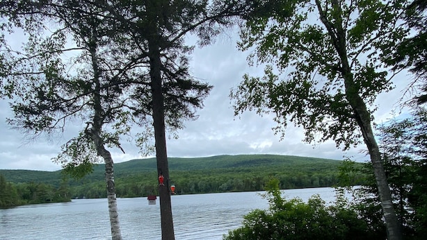 Kivipolku johtaa järvenrantaan, jossa on oleskelualue ja Adirondack-tyylisiä puutarhatuoleja.