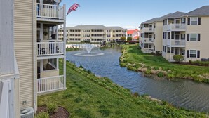 A residential building with a balcony, a small water feature, and a flag.