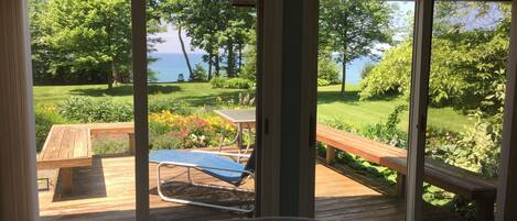 Una habitación con vista a un jardín y una terraza de madera.