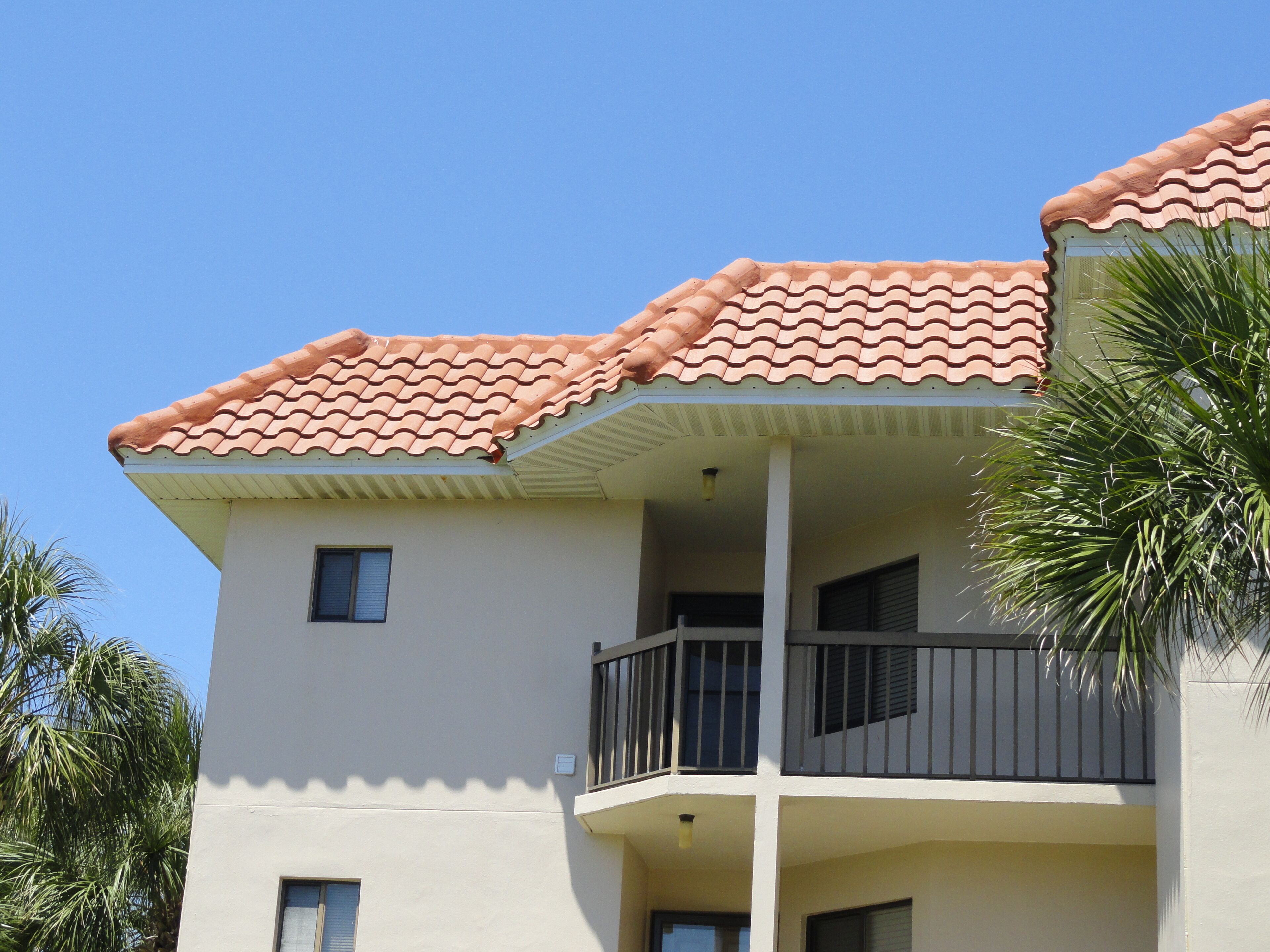 A multi-story building with a tiled roof, balconies, and windows.