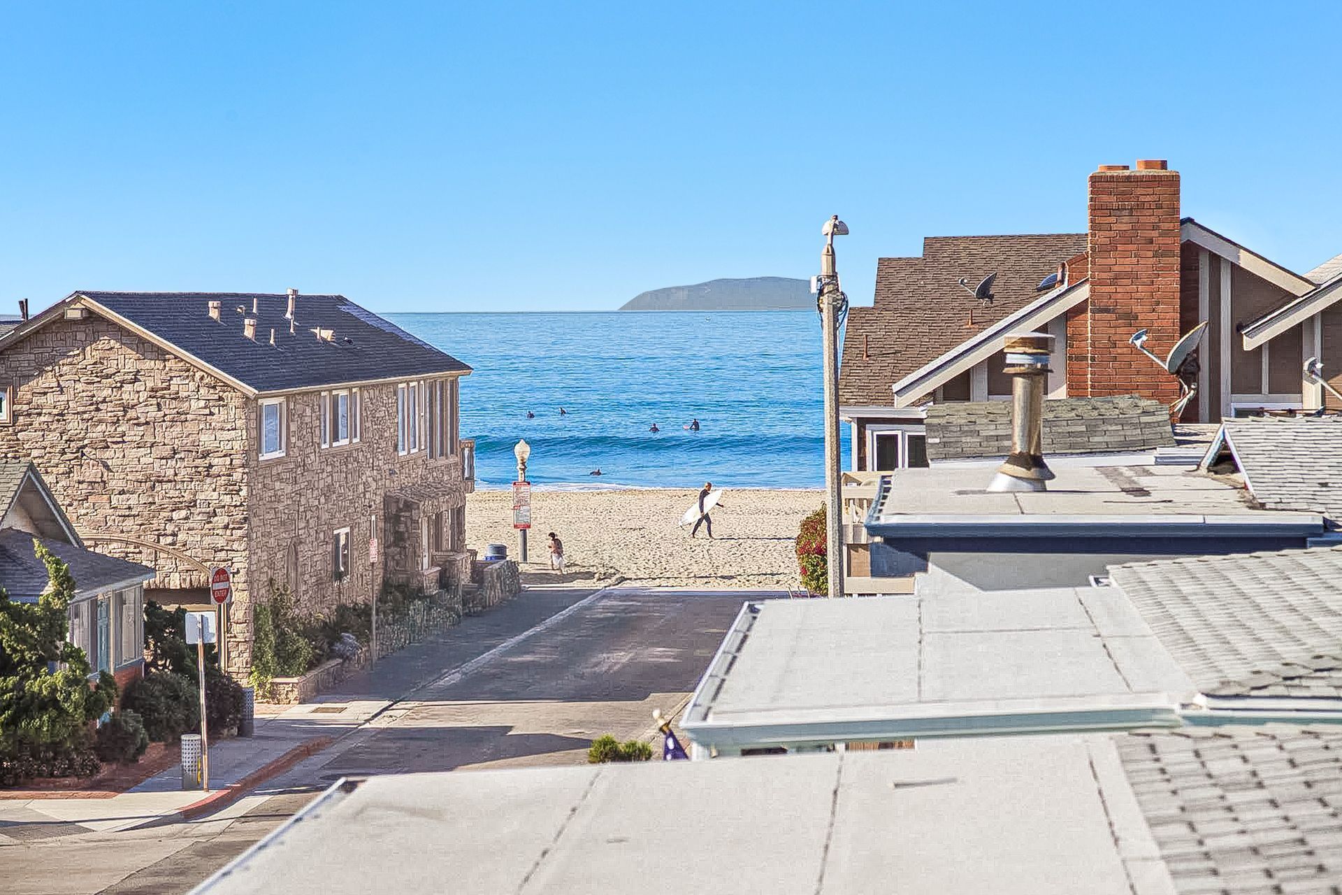 A coastal town with stone buildings, a beach, and a clear view of the sea.