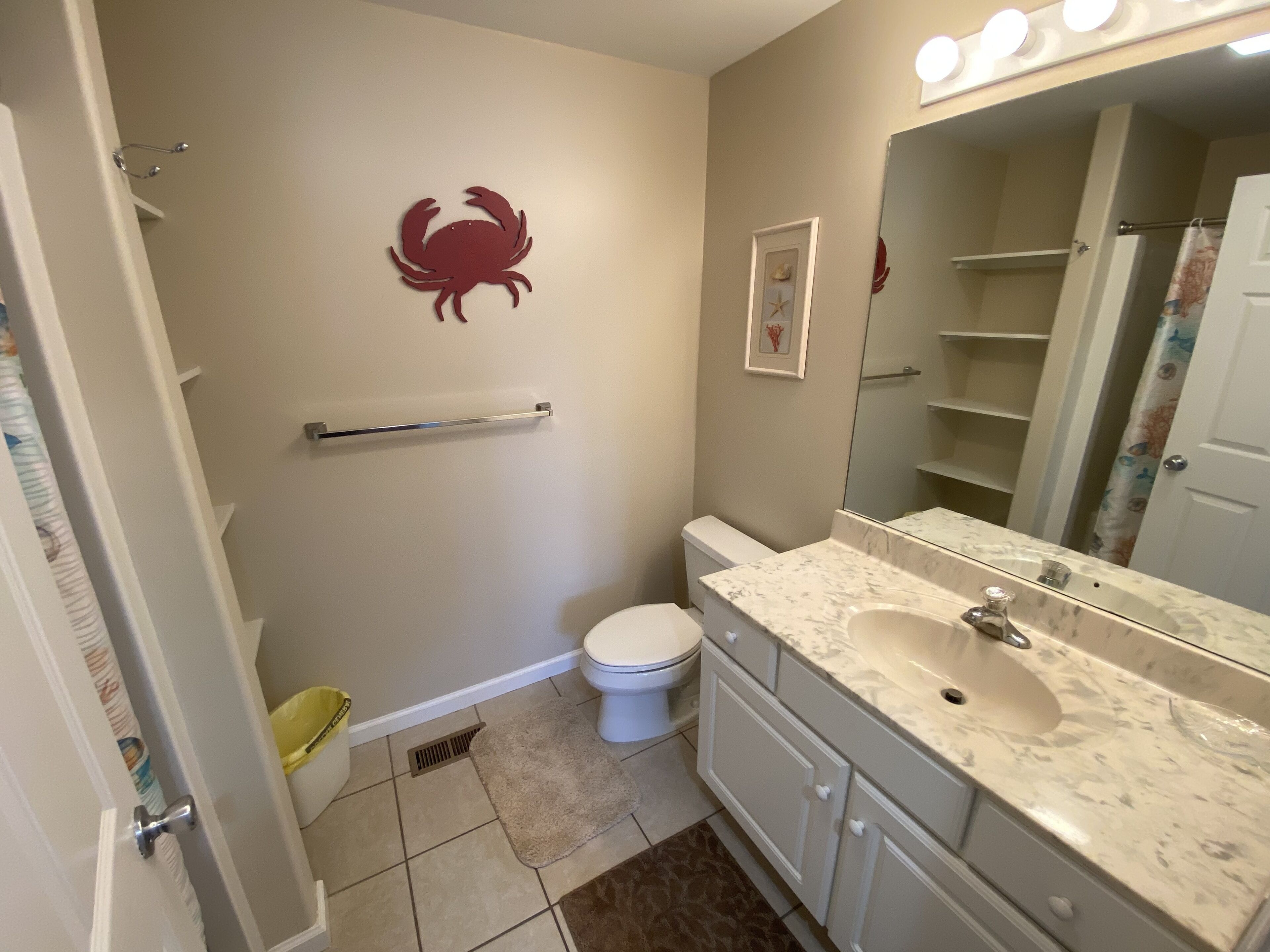 Ein Badezimmer mit Toilette, Waschbecken, Waschtisch und Spiegel.