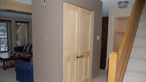 Une pièce avec une grande armoire en bois, un canapé bleu et une petite table.