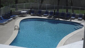 A swimming pool with blue water, surrounded by lounge chairs and a fence. - Tidewater 2nd Floor-Awesome Gulf Front 3BR - Indoor & Outdoor Pools (Orange Beach)
