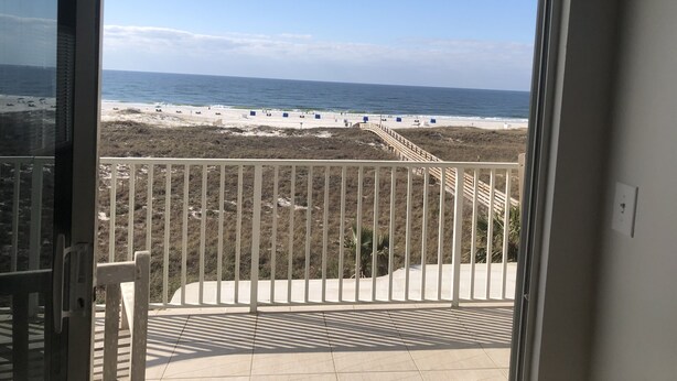 A balcony with a view of the beach, including a sandy area and a wooden walkway. - Tidewater 2nd Floor-Awesome Gulf Front 3BR - Indoor & Outdoor Pools (Orange Beach)
