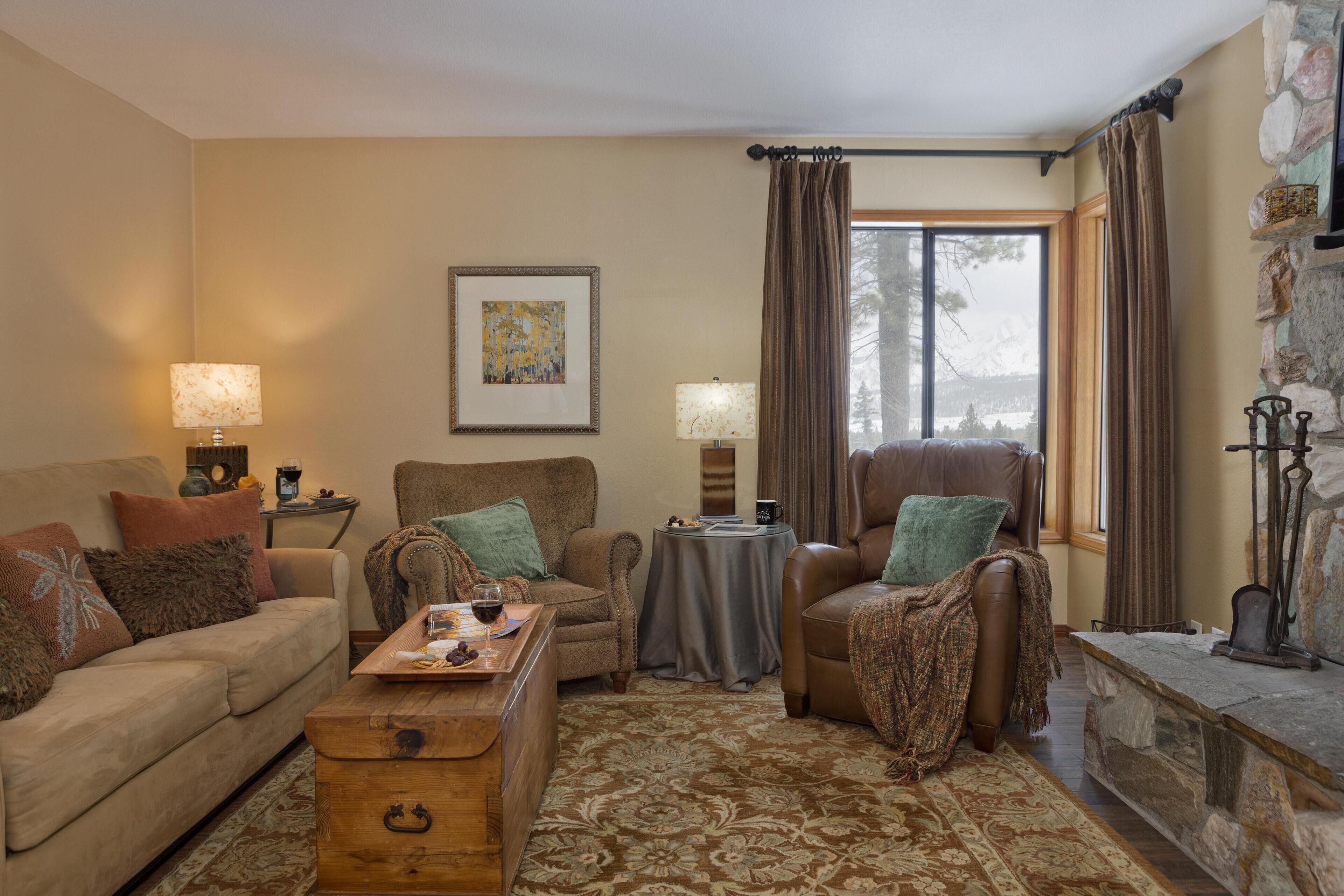 Una sala de estar acogedora con un sofá, sillones, una mesa de centro y una chimenea.