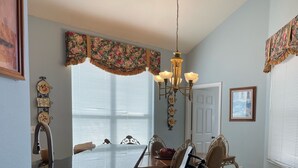 A dining area with a table, chairs, and a chandelier. - S-Facing Pool, 3.6 mi from Disney, man-gated resort, wheelchair accessible (Kissimmee)