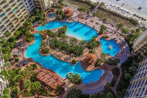 A resort with multiple swimming pools, palm trees, and beach views. - 1112: Luxury Beachfront Condo w/Reserved Parking & Wifi (Panama City Beach)