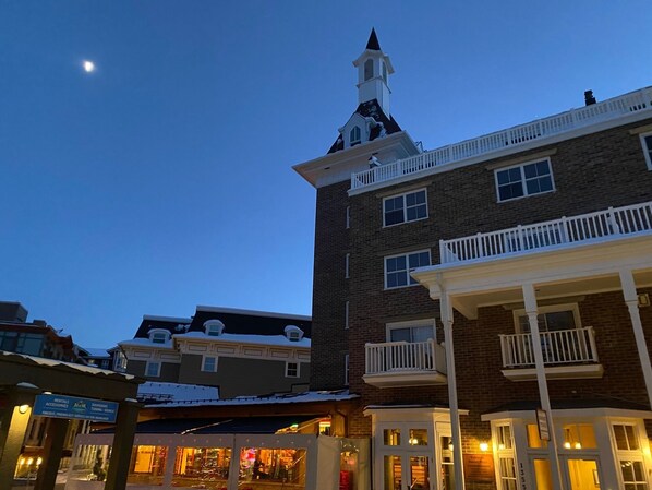 A multi-story building with a prominent tower and balcony.