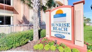 A sign for Sunrise Beach Condominium with a number 14825.