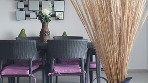 A dining area with wicker chairs, a table, and a vase of tall, golden grasses. - Oceanside, spectacular views, very big 2 bdr condo in Cancun (Cancún)