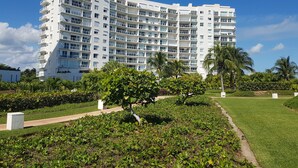 A multi-story hotel with balconies, surrounded by well-maintained greenery and palm trees. - Oceanside, spectacular views, very big 2 bdr condo in Cancun (Cancún)