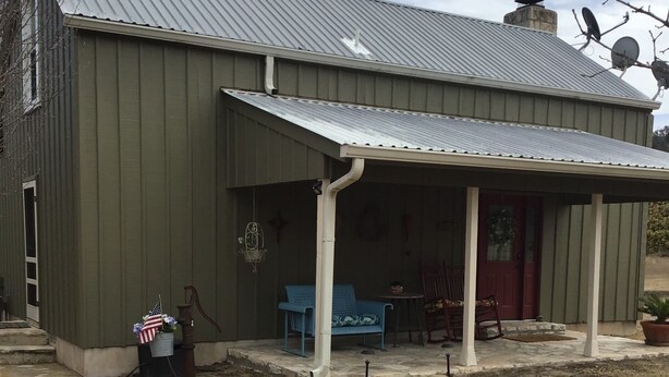 A rustic barn-style building with a covered porch, stone pathway, and outdoor seating area. - ACE OF HEARTS The perfect getaway! Only 3.5 miles from Main Street. (Fredericksburg)