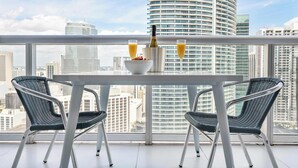 Un coin repas moderne avec une table et des chaises, une bouteille de champagne et deux verres de jus d’orange.