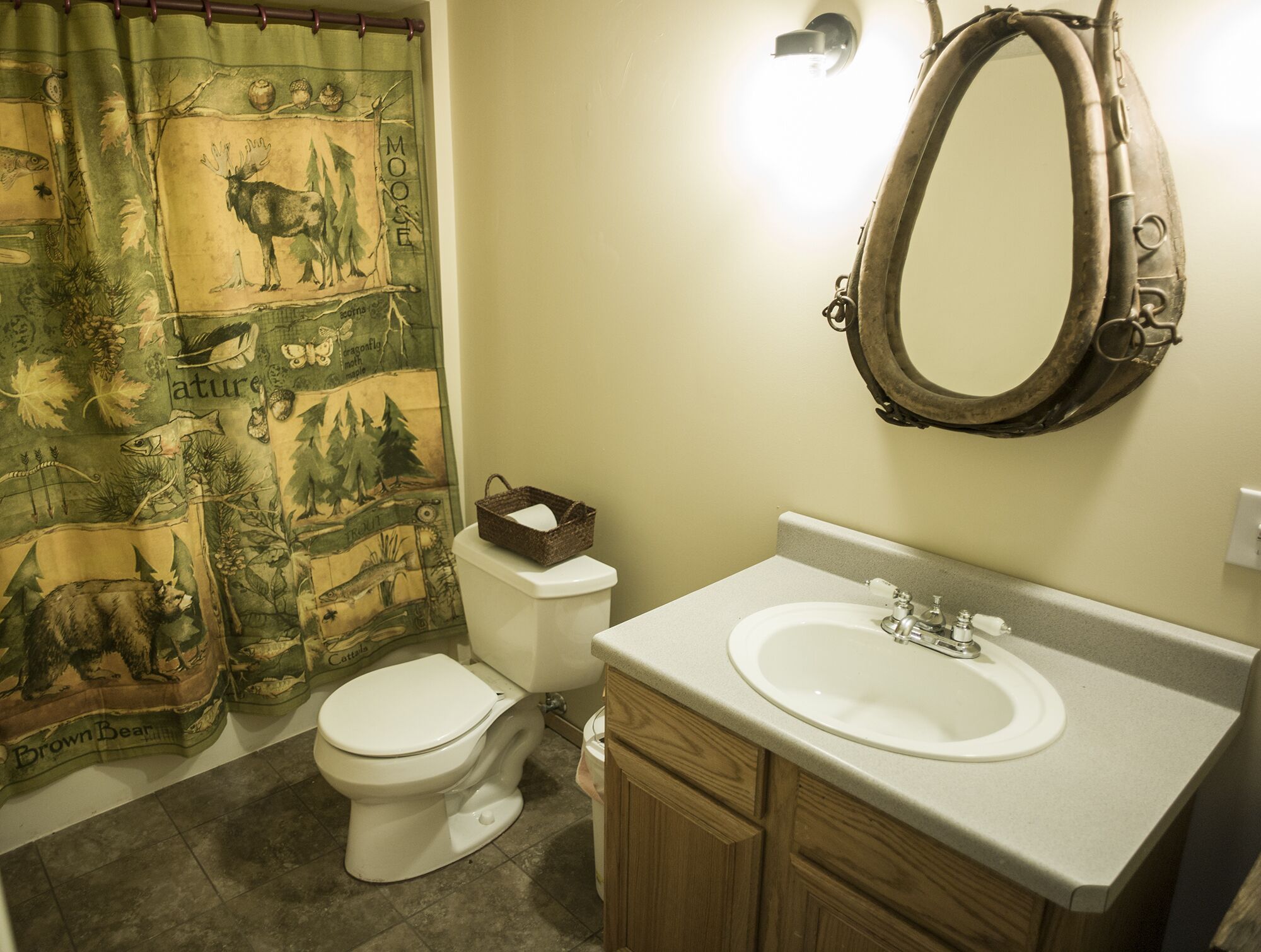 A bathroom with a toilet, sink, and a mirror.