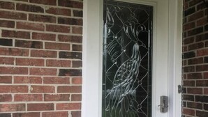 Une porte ornée d’un panneau de verre décoratif représentant un motif d’oiseau.