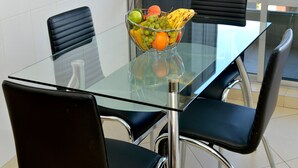 A modern dining area with a glass table and black chairs. - BEAUT on Ave Gonzalez Suarez, GRT LOC, WiFi, Pool, JacuZ, SAU, Gym, PKG, Promos. (Quito Canton)
