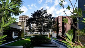 A courtyard with a central tree, surrounded by buildings. - BEAUT on Ave Gonzalez Suarez, GRT LOC, WiFi, Pool, JacuZ, SAU, Gym, PKG, Promos. (Quito Canton)