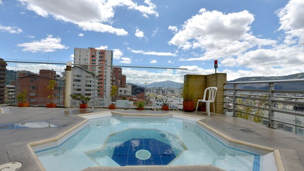 A rooftop swimming pool with a view of a cityscape and mountains in the background. - BEAUT on Ave Gonzalez Suarez, GRT LOC, WiFi, Pool, JacuZ, SAU, Gym, PKG, Promos. (Quito Canton)