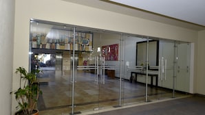 A modern interior with a glass partition, a potted plant, and a staircase leading to an upper level. - BEAUT on Ave Gonzalez Suarez, GRT LOC, WiFi, Pool, JacuZ, SAU, Gym, PKG, Promos. (Quito Canton)