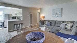 A modern living room with a grey sofa, a wooden coffee table, and a blue woven basket. - Large 5 Bedroom House Beach side in Mission Beach (San Diego)