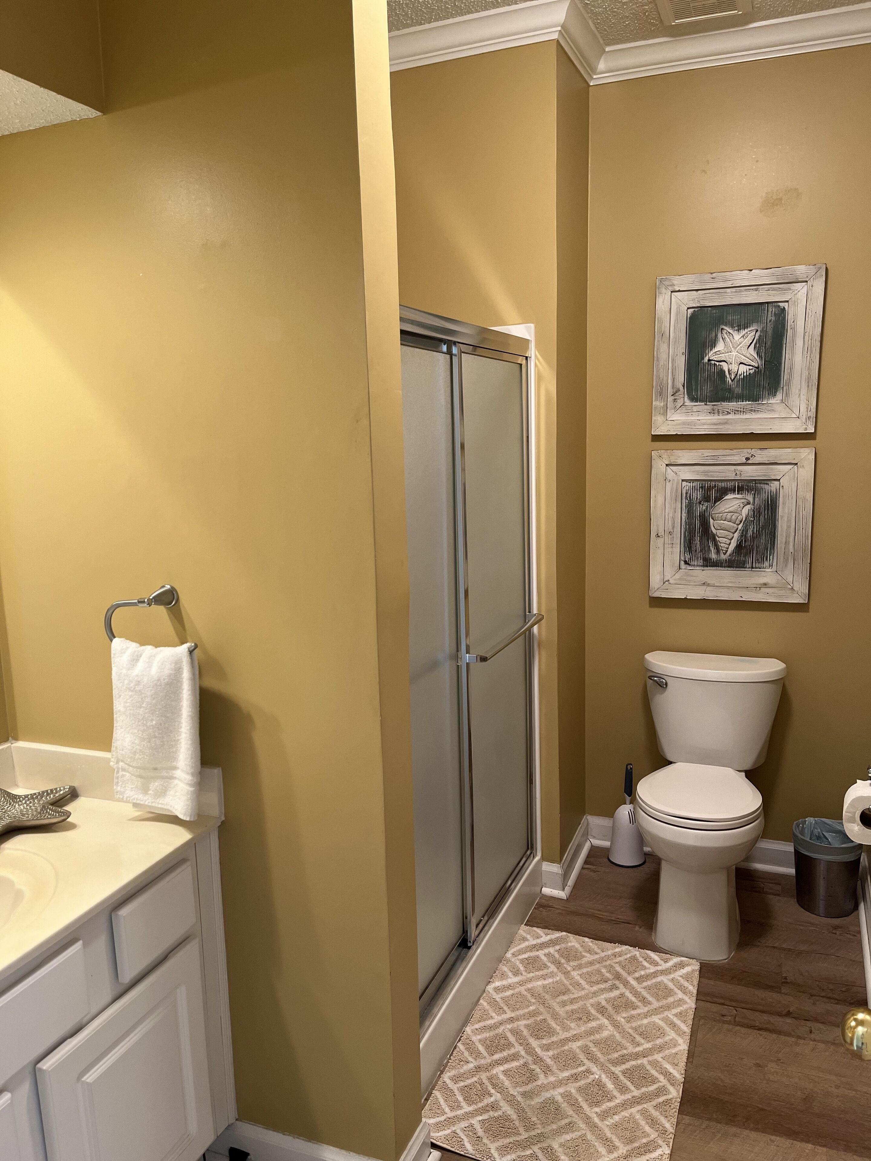 A bathroom with a shower, toilet, and sink.