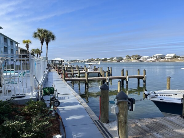 A waterfront dock with boats, a pool area, and a building with balconies.