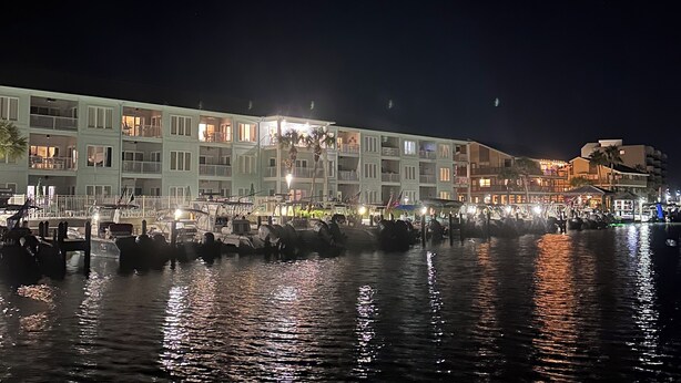 A waterfront hotel with multiple balconies, a marina with boats, and a well-lit facade. - Recently updated!  3 bed 3 bath waterfront condo (Orange Beach)