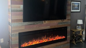 A modern living room with a flat-screen TV mounted above a fireplace. - Beautiful home on Clear Lake! Amazing views 🌅 Great fishing 🎣 Great boating 🚤 (Lake City)