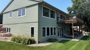 A two-story house with a balcony and a covered patio area. - Beautiful home on Clear Lake! Amazing views 🌅 Great fishing 🎣 Great boating 🚤 (Lake City)
