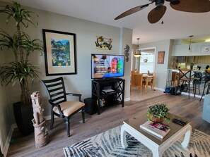 A living room with a television, a dining area, and a kitchen.