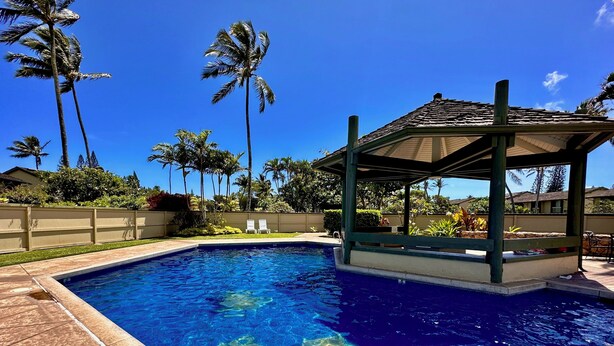 A swimming pool with clear blue water, surrounded by palm trees and a covered pavilion. - Resort Living Off the Beaten Path
AC , WIFI, and Fully Remodeled Bathroom (Kahuku)