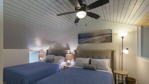 A bedroom with two beds, a ceiling fan, a nightstand with a lamp, a wall-mounted painting, and a floor lamp. - Resort Living Off the Beaten Path
AC , WIFI, and Fully Remodeled Bathroom (Kahuku)