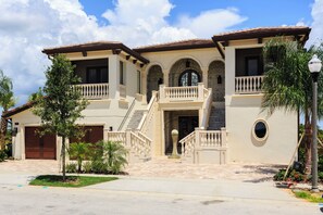 A two-story house with a front entrance, a staircase, and a garage. - Waterfront Home-Bowling Alley, Cinema, Sauna, Outdoor Grilling, Pool w/ Slide  (Four Corners)
