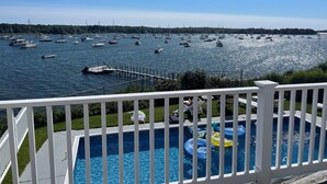 A pool area with a view of a marina filled with boats.