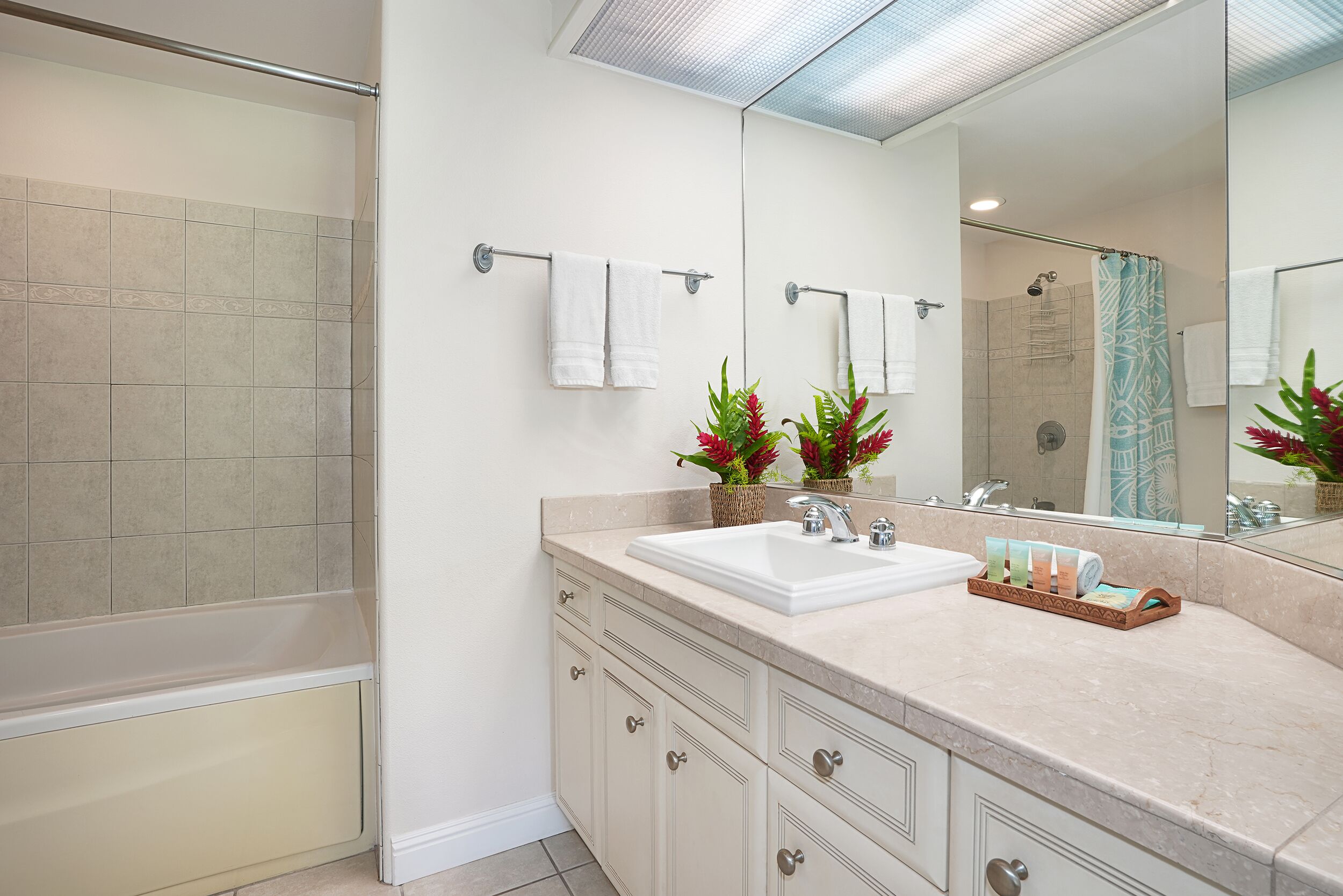 A modern bathroom with a bathtub, a sink with a mirror, and a shower area.
