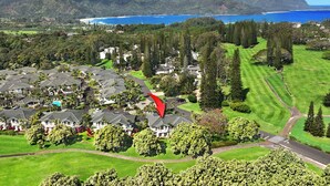 Zona residencial con casas, un campo de golf y vista al océano.