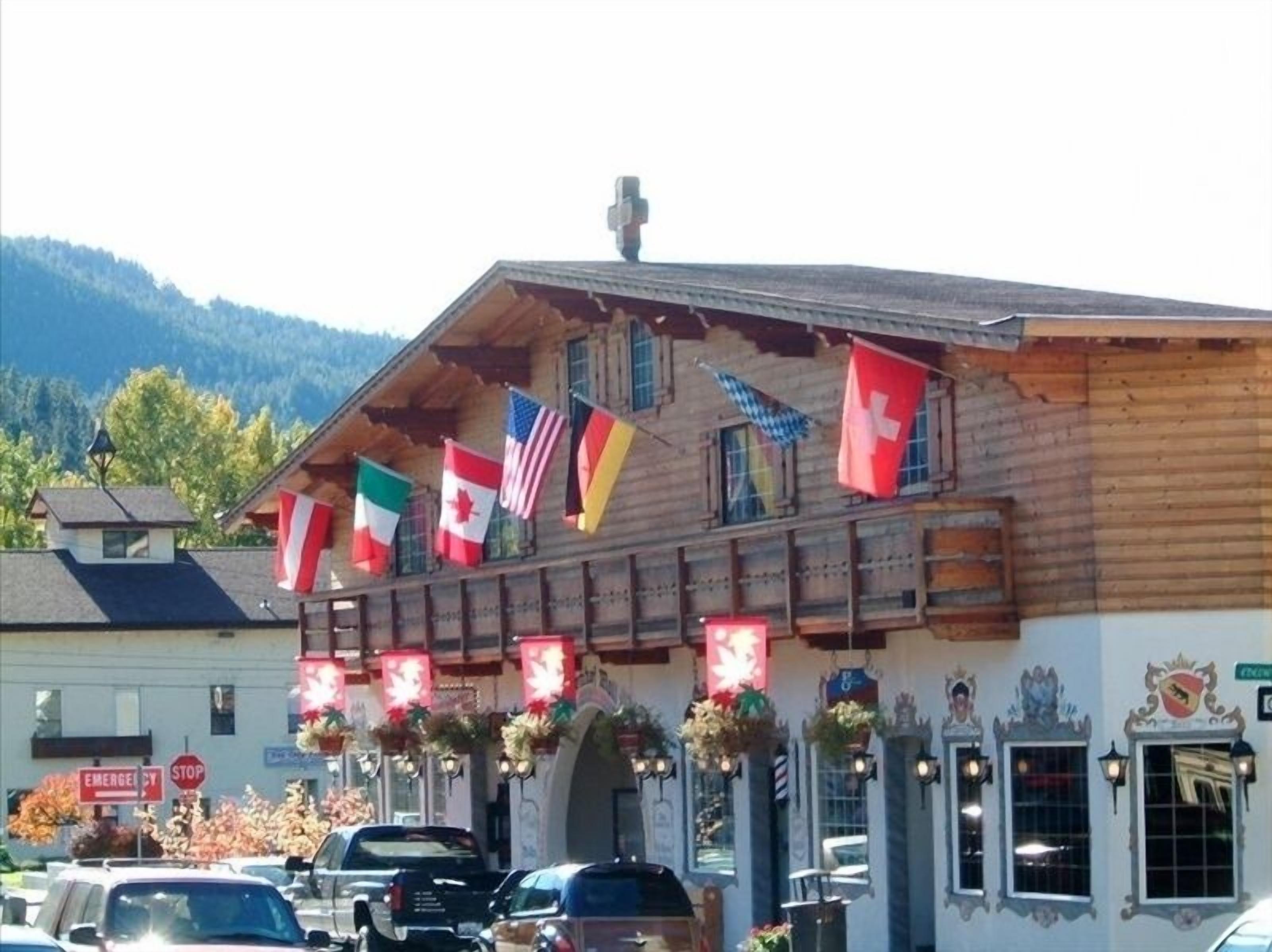 A wooden building with multiple flags, including the Swiss flag, and a sign that reads "EMERGENCY STOP".