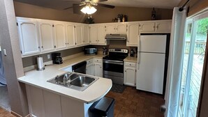 A kitchen with white cabinets, stainless steel appliances, and a ceiling fan. - Branson area Lakehouse, 5 Bedrooms, 3 Baths, (Sleeps 9-15) New decks Spring 2019 (Kimberling City)