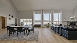 A spacious living area with a dining table, chairs, a sofa, and a fireplace.