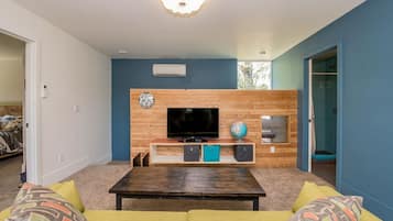 Relax in this stylish living room with a flat-screen TV, comfortable sofa, and decorative touches.