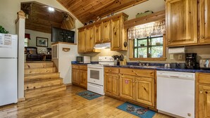 A kitchen with wooden cabinets, a stove, a dishwasher, and a window with a view of the outdoors. - Lake Front with Lake view, King size Bed Great Place to relax and go fishing (Sevierville)