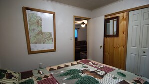 Una habitación con un gran mapa en la pared, una puerta de madera y un colcha en la cama.