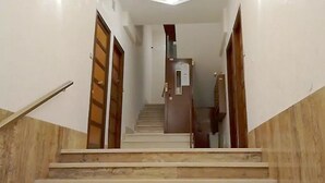 A staircase with wooden doors on either side, leading to a landing with a light fixture above. - Lovely and Cheap Flat in the Central Area Appio -San Giovanni (rome)