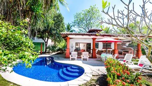 A swimming pool surrounded by a patio with outdoor furniture, a covered seating area, and lush greenery. - 4 bed / 4 bath w pool and rooftop patio 50m from Beach in Grande (playa grande)