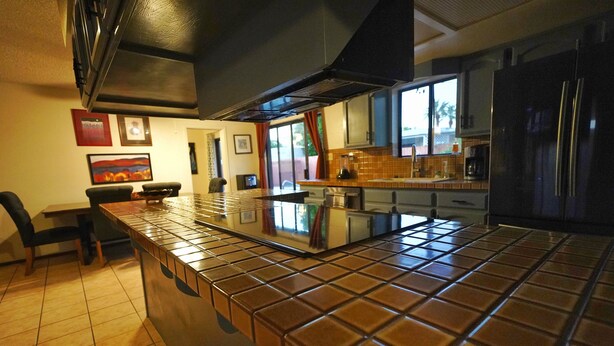 Una cocina moderna con salpicadero de azulejos, electrodomésticos de acero inoxidable y una isla central.