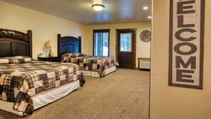 A bedroom with two beds, a clock, and a 'WELCOME' sign. - Queen Suite at Ponds Lodge Cabin 31 Unit 1 (Island Park)
