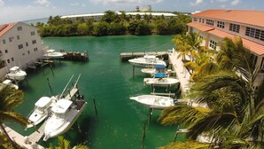 Un port de plaisance où sont amarrés plusieurs bateaux, entouré de bâtiments et de verdure.