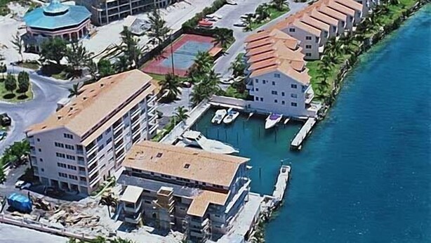 Vue aérienne d’un complexe hôtelier comprenant plusieurs bâtiments, une piscine et un port de plaisance.